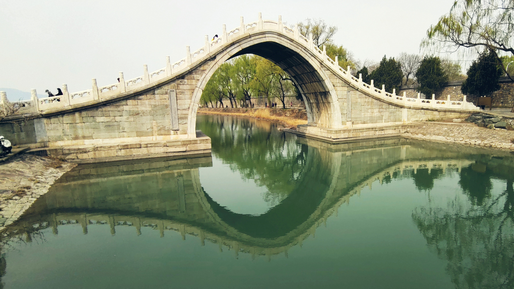 远处的拱桥,在碧水的映衬之下,显露出几分唯美和妖娆.